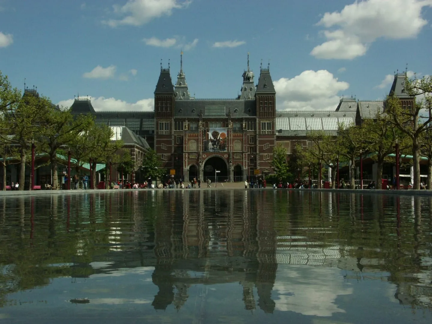 The red brick Rijksmuseum reflected in the long pool on Museumplein