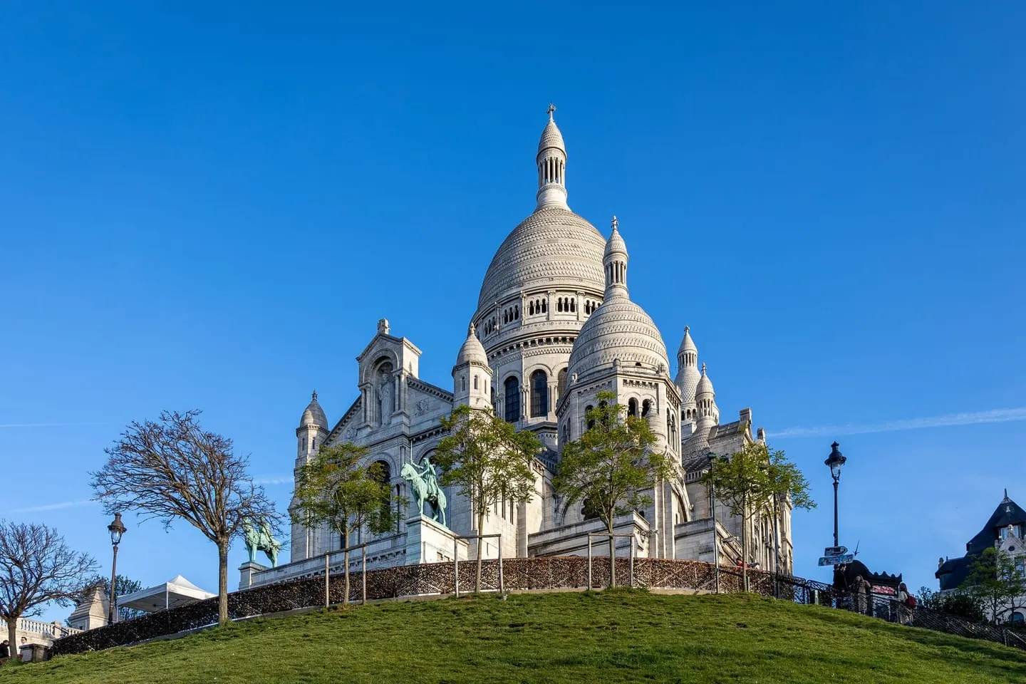 The white domes of the Sacré-Cœur Basilica on top of Montmartre under a blue sky