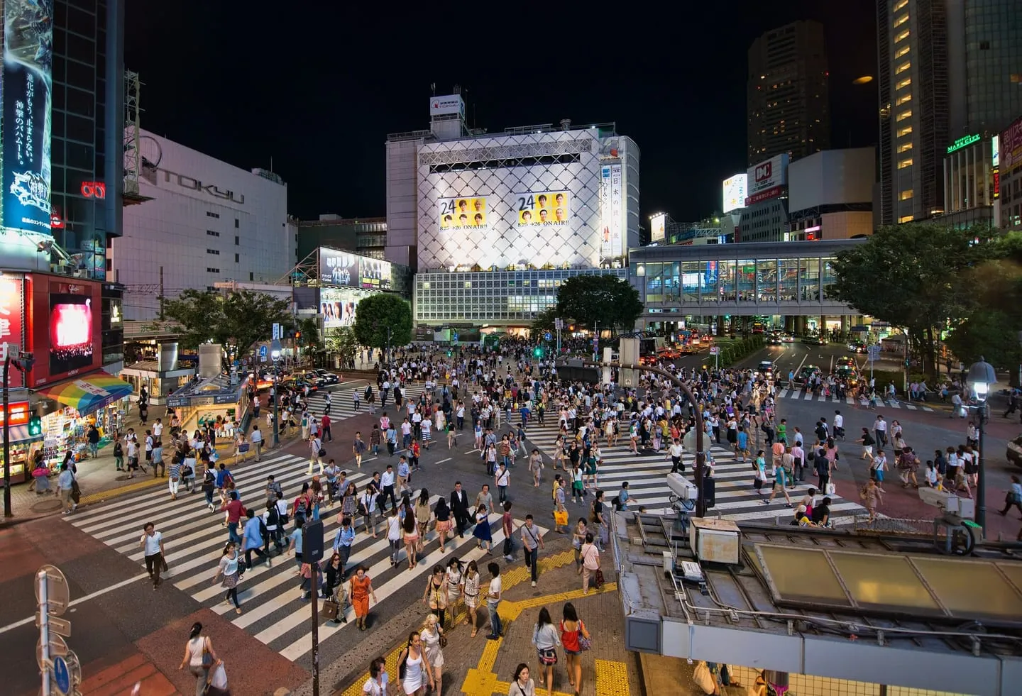 Crowds crossing the Shibuya scramble crossing in all directions, seen from above