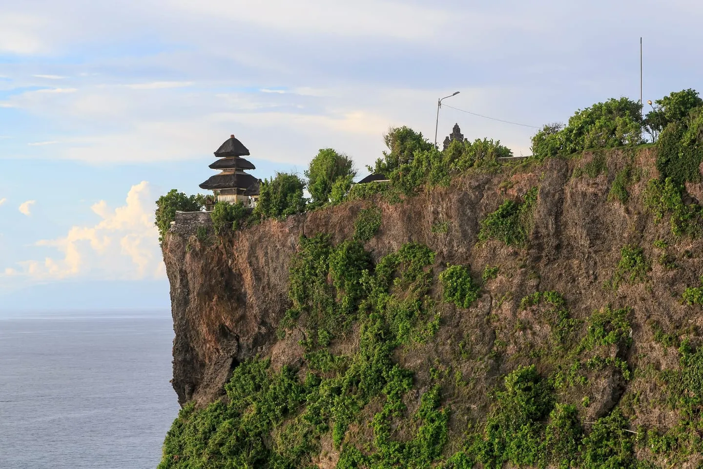 Pura Luhur Uluwatu’s thatched shrine on the edge of a sheer limestone cliff above the ocean