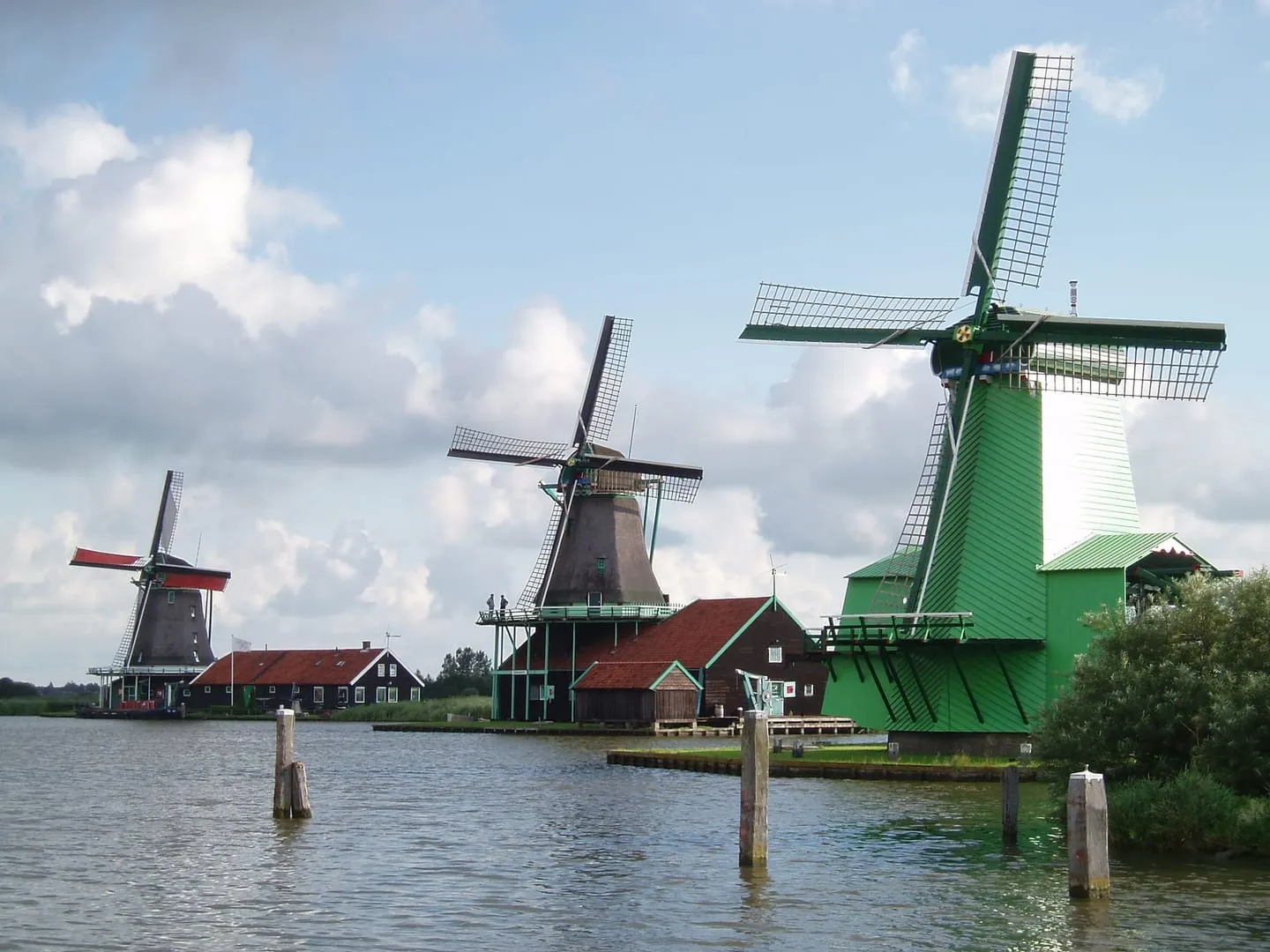 Wooden windmills lined up along the river Zaan at Zaanse Schans